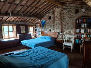 1 dormitorio con 2 camas y estante para libros en Attic with balcony at Locanda del Capo, en Capannori