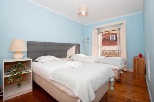 a bedroom with two beds with white sheets and a window at Condessa Vintage Apt Chiado in Lisbon