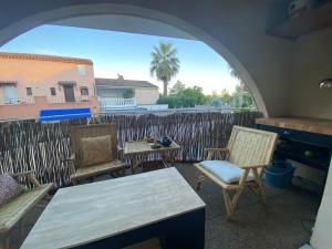 a patio with chairs and a table and a fence at Studio à Port Grimaud in Grimaud
