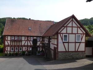a house with a red and white building at Ferienwohnung Menz - Alte Mühle - mit Milseburgblick und Gartenpool in Hofbieber