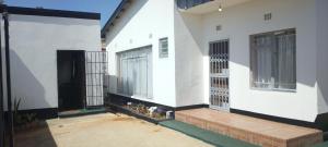 卢萨卡LaJoy Lodge的白色的房子,设有门廊和门