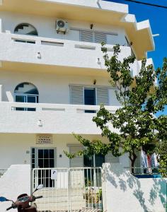 a white building with a scooter parked in front of it at COSY Urban Living in Kos Town