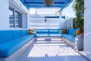 eine Terrasse mit einem blauen Sofa und einem Fenster in der Unterkunft Villa in Golf Resort with Shared Pool in Bouznika