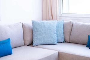 eine Couch mit blauen Kissen im Wohnzimmer in der Unterkunft Villa in Golf Resort with Shared Pool in Bouznika + 50 Fotos