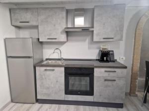 a kitchen with a sink and a stove and refrigerator at Living Milano Suite in Cinisello Balsamo