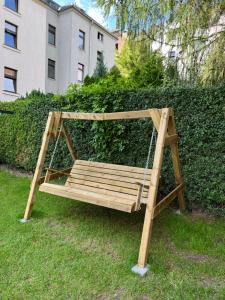 a swing sitting in the grass in front of a hedge at Home by Ginger in Reichenbach im Vogtland