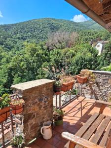 un patio con mesa, sillas y una montaña en Attic with balcony at Locanda del Capo, en Capannori