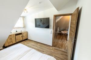 una camera da letto con porta in legno e specchio di Ferienbahnhof Fichtental Bahnhofs-Loft a Prackenbach