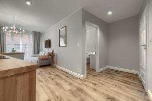 eine Küche und ein Wohnzimmer mit weißen Wänden und Holzböden in der Unterkunft Apartamenty MUNN 3 Szczecin in Stettin
