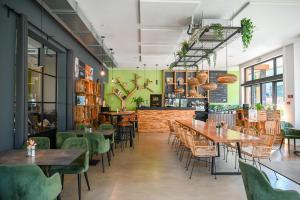 a restaurant with wooden tables and green chairs at het Boekenhof in Niel