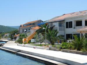 a row of buildings next to a body of water at Apartments Kalafatović in Drače