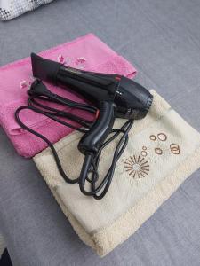 a black hair dryer sitting on top of a towel at Zeytin apart, Daire 10 in Eskiömerler