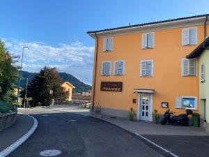 BalernaAlbergo Ristorante Stazione Balerna的停在街道旁的一座带摩托车的建筑