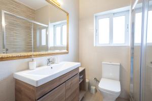 a bathroom with a sink and a toilet and a mirror at Sofia's seaview house in Platanias +20 photos