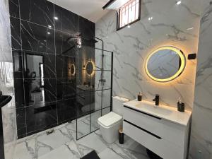 RufisqueにあるVilla climatisé avec piscine et calmeのトイレ、シャワー、洗面台を備えたバスルーム +16枚の写真