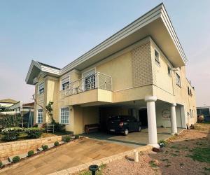 una casa con un coche aparcado delante en Guest House Botânico, en Curitiba