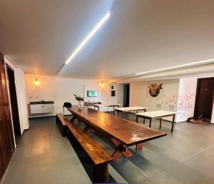 a large room with a large wooden table and benches at Hostel Residencial Botânico in Curitiba