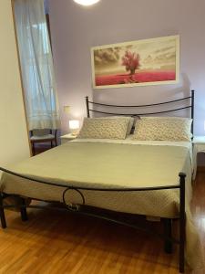 a bedroom with a bed with a painting on the wall at Al Duomo in Ronciglione