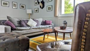 a living room with a couch and a table at Le Cottage Limousin - gîte de charme en bord de Vienne, Limoges - airport in Saint-Brice-sur-Vienne
