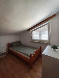 a small bedroom with a bed and a window at Apartment Vir in Vir