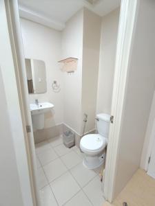 a white bathroom with a toilet and a sink at Cebu Stay Rental - Sunvida Tower Residences in Cebu City