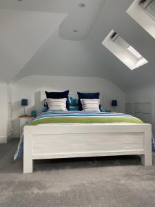 a bedroom with a large white bed in a room at Cranbrook on the river lym walk in Uplyme in Uplyme
