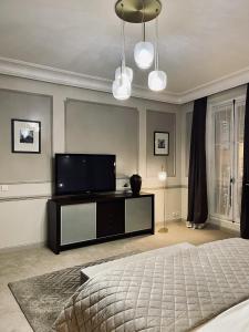 a bedroom with a bed and a flat screen tv at L'appart du centre in Paris