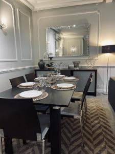 a dining room with a table with chairs and a mirror at L'appart du centre in Paris +10 photos