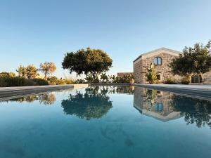 a pool of water in front of a building at Papalei La Maison in Ragusa