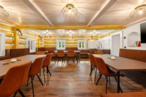 a restaurant with wooden floors and tables and chairs at Chalupa Sport Buřany in Jablonec nad Jizerou