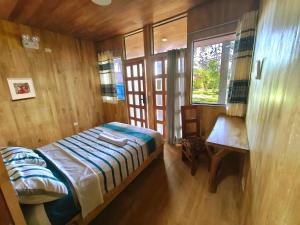 a bedroom with a bed and a table and a window at Retazos Eco Hotel in Iquitos