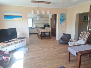 a living room with a television and a dining room at Kevade Apartement in Viljandi