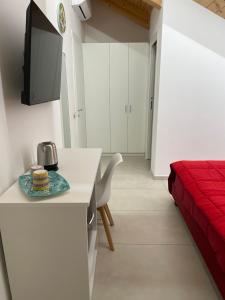 a small white kitchen with a table and a bed at B&B Casa Salsano in Vietri sul Mare