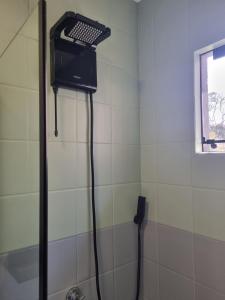 a shower in a white tiled bathroom at A 700m da Praia e do Shopping, Liberdade, Churrasq, Garagem e Estaciona Livre in Balneário Camboriú +21 photos