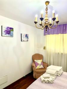 una camera da letto con un letto, una sedia e un lampadario di Tavernetta La Lavanda annessa a Suite Apartment Assisi ad Assisi