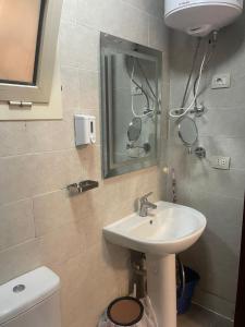 ein Badezimmer mit Waschbecken, Spiegel und Toilette in der Unterkunft 3 bedroom apartment Marina Residence New Alamein in El-Alamein
