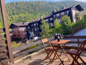 a table with two chairs and a glass of wine on a balcony at Aprica Mountain Life in Aprica