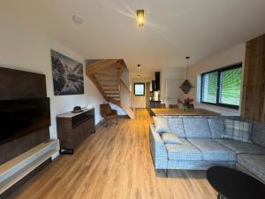 a living room with a couch and a television at Chalets Dualhaus, 2 Apartments mit Sauna, Nähe Pressegger See, Skibus zum Nassfeld in Hermagor