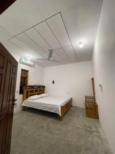 a bedroom with a bed in a white room at The luxy bay in Arugam Bay