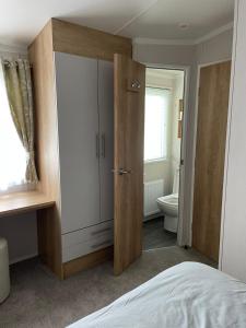 a bedroom with a large wardrobe and a toilet at Happy Holiday Seton Sands in Port Seton
