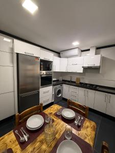 cocina con mesa de madera con sillas y comedor en Lujoso Apartamento, en Martil 14 fotos más