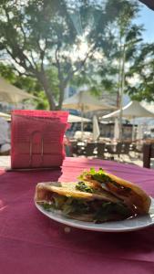 a sandwich on a white plate on a table at Appartamenti Gabicce Mare in Gabicce Mare