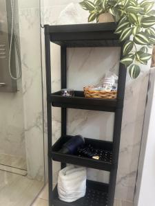 a black shelf with a basket on it in a bathroom at Panoramic RESIDENCE in Baia Mare +36 photos