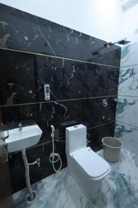 a bathroom with a white toilet and a sink at Hotel Shri Balaji Dham, Family Room Near Mathura Railway Station in Mathura