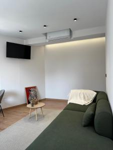 Una sala de estar con un sofá verde y una mesa. en Lemos Agra, en Monforte de Lemos