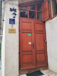 a large wooden door on a building with a sign on it at Rooms Poli Luce - Room Zvane in Gračišće