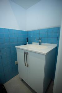 a bathroom with a white sink and blue tiles at Sea View Boutique Apartments in Chakvi +38 photos