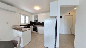 a kitchen with white appliances and a white refrigerator at Villa Bell'Aria Korcula in Vela Luka +33 photos