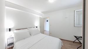 a white bedroom with a white bed and a mirror at Villa Bell'Aria Korcula in Vela Luka