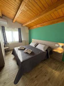 a bedroom with a large bed with a green wall at Come a Casa in Santa Maria del Cedro